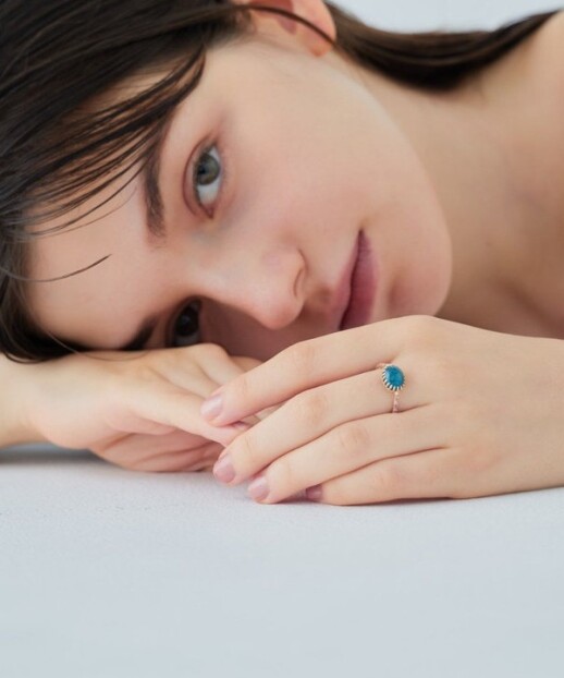 リングアームに連ねたロードライトガーネットのカラーが、ブルーアパタイトの色合いをいっそう引き立てます